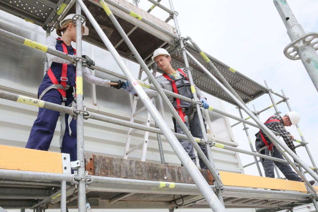 Construction,Workers,Installing,Scaffolding,On,Site