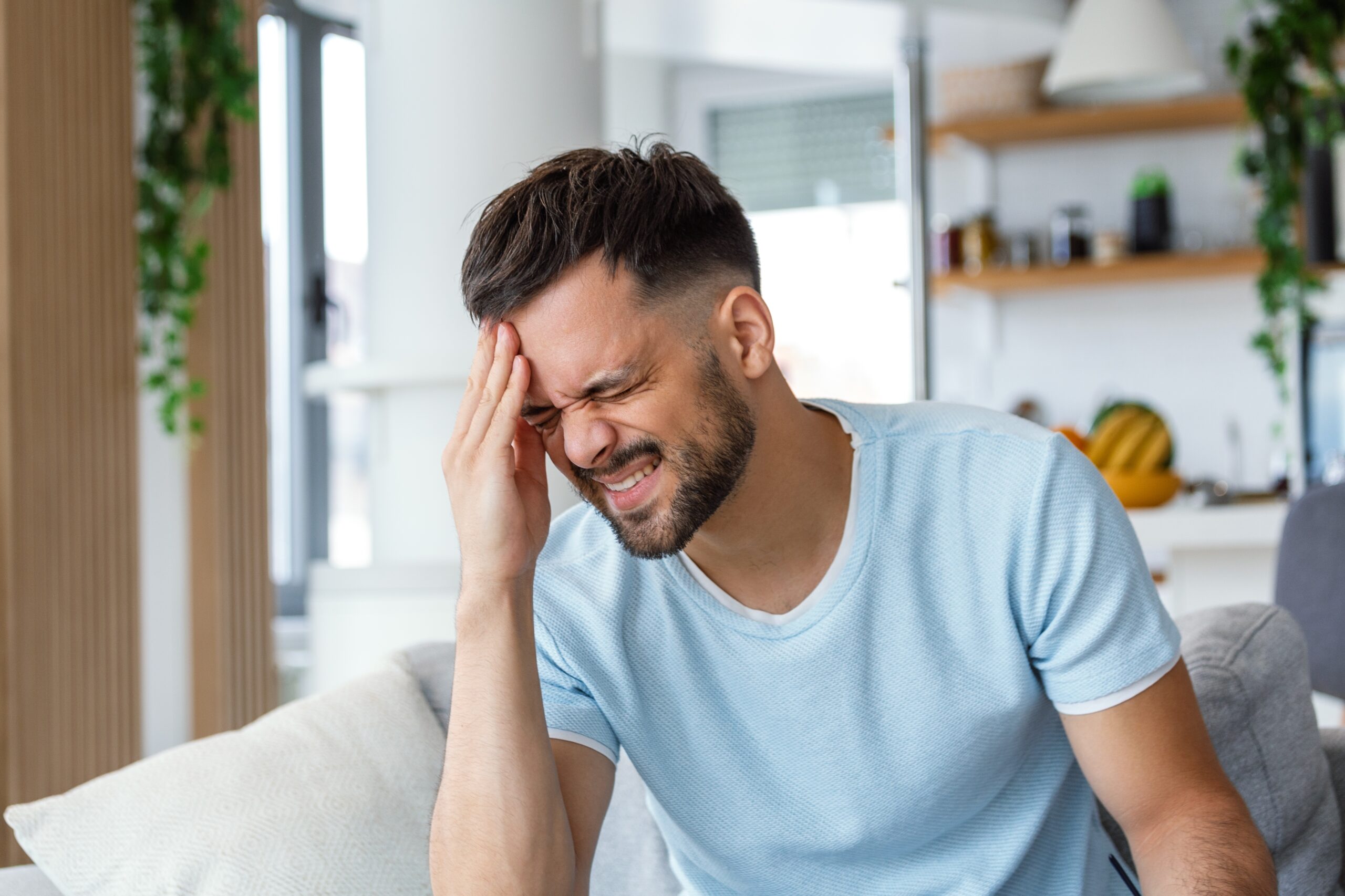 Closeup,Of,Young,Man,Suffering,From,Headache,At,Home,,Touching