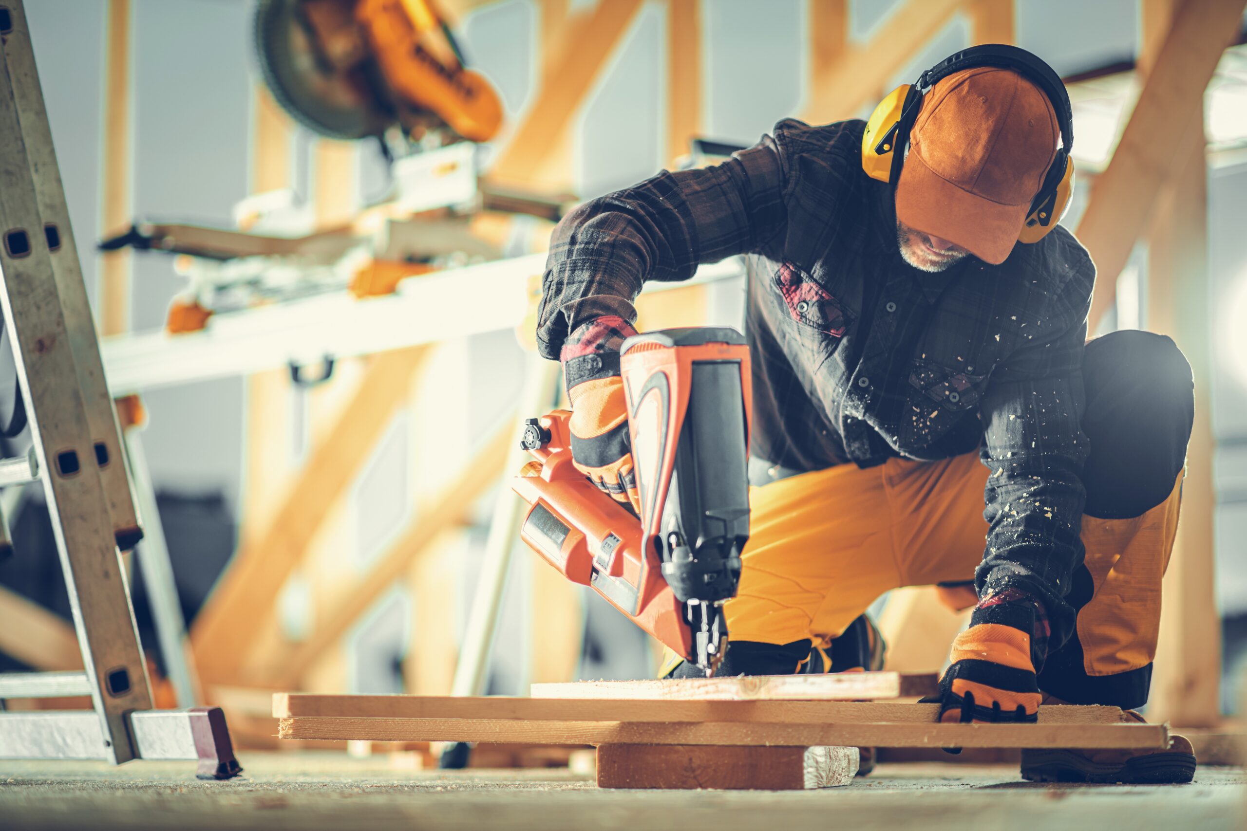 A,Focused,Worker,Kneels,On,A,Wooden,Surface,,Skillfully,Using