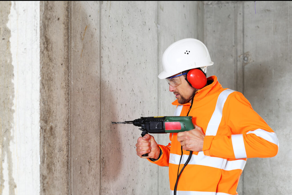 A,Worker,Man,Drilling,In,Concrete,On,A,Construction,Site